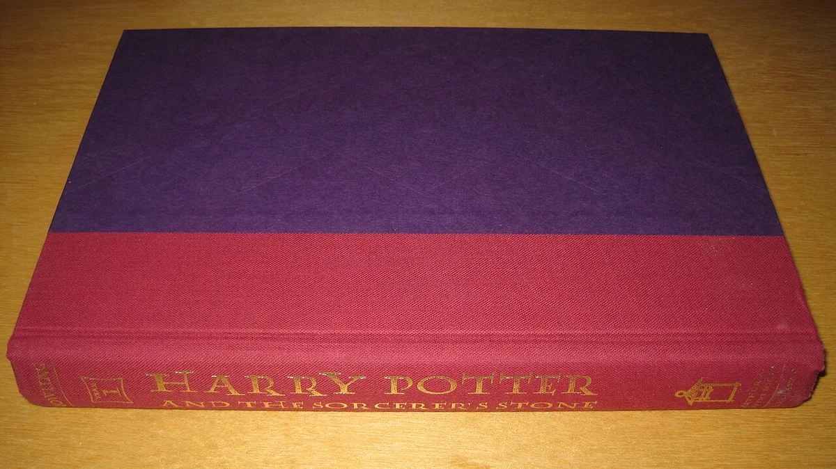 Hardback of Harry Potter and the Sorcerer's Stone without its jacket, purple boards and red cloth spine