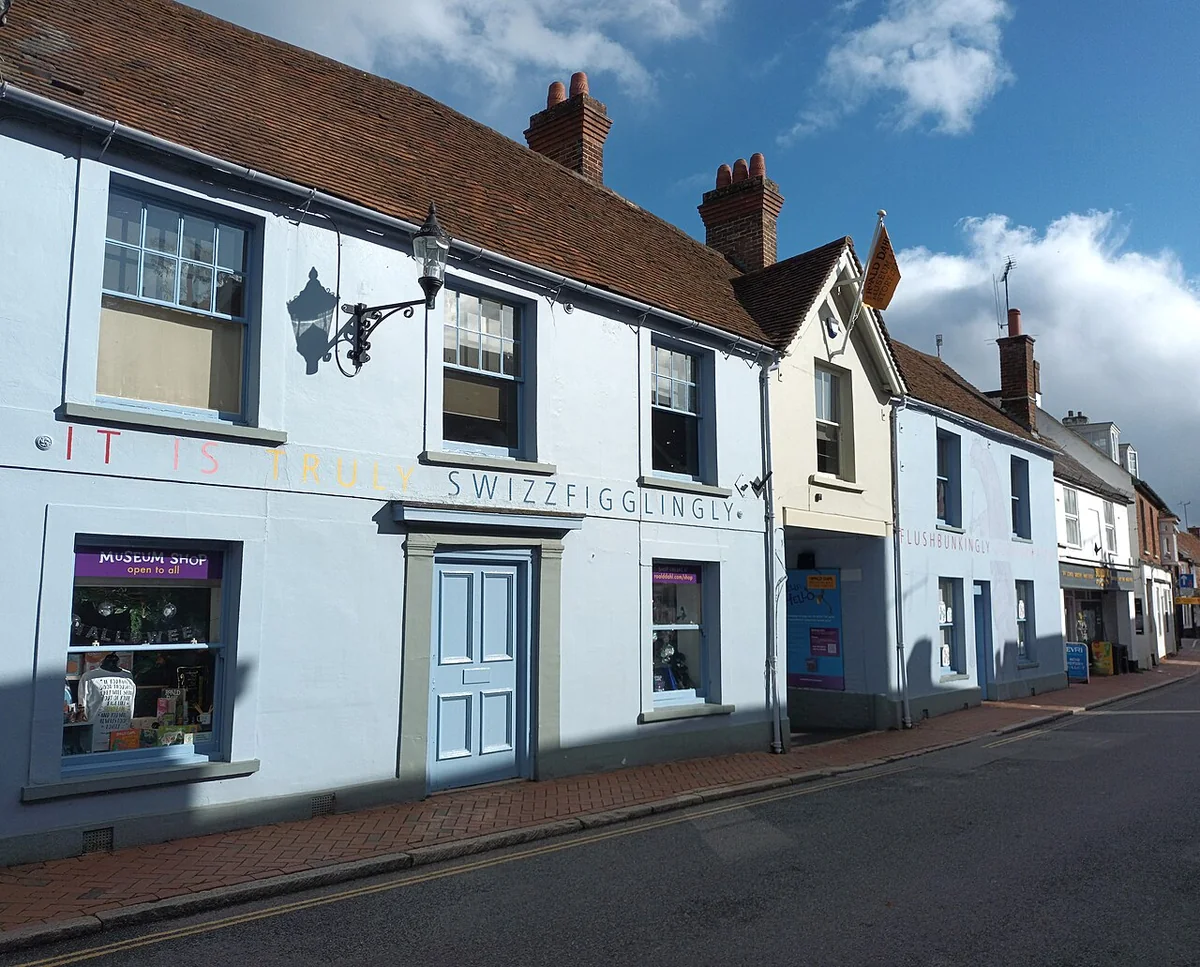 White painted buildings of the Roald Dahl Museum and Story Centre along Great Missenden High Street under a blue sky